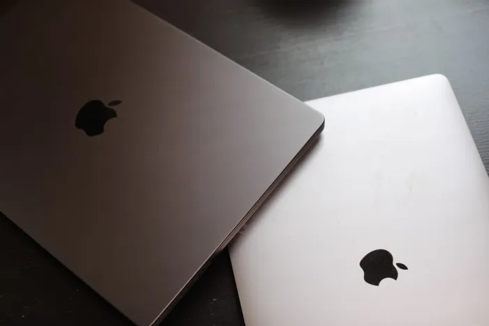 Dos MacBook cerradas, con el logo de Apple, sobre una mesa oscura