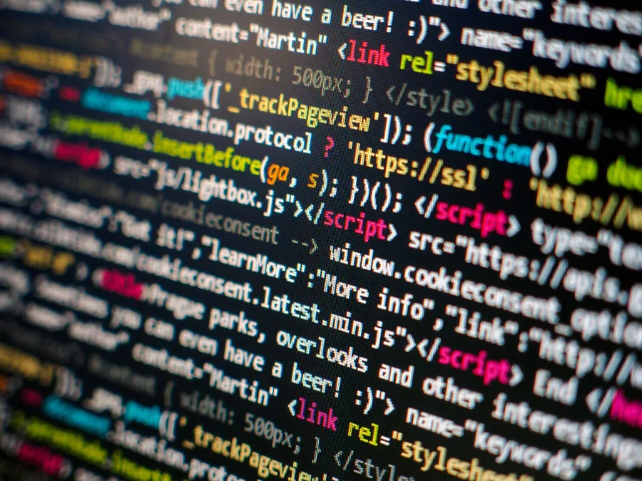 Primer plano de código fuente coloreado por sintaxis en una pantalla oscura